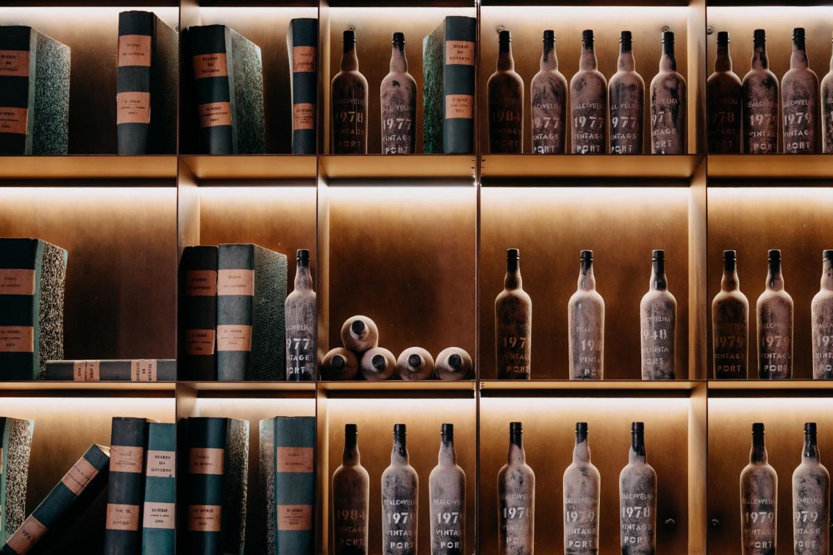 uma prateleira com garrafas de vinho e livros em Casa da Companhia Hotel & Spa, Vignette Collection by IHG no Porto