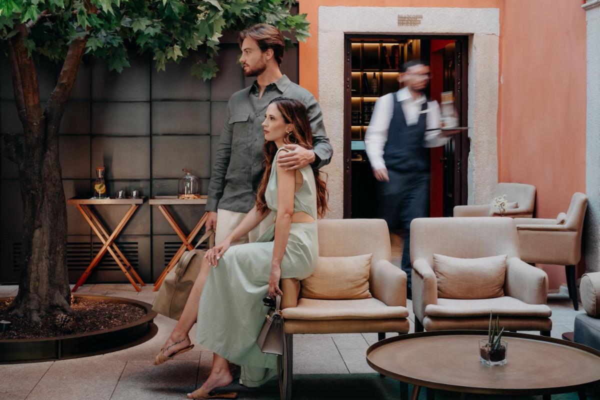 um homem e uma mulher parados em frente a um prédio em Casa da Companhia Hotel & Spa, Vignette Collection by IHG no Porto
