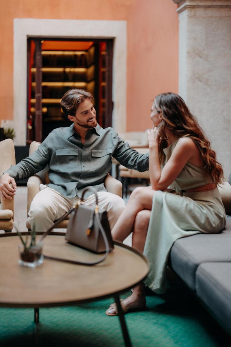 um homem e uma mulher sentados em um sofá em Casa da Companhia Hotel & Spa, Vignette Collection by IHG no Porto mais 105 fotografias