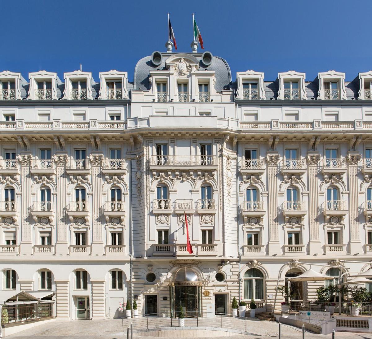 - un grand bâtiment blanc avec drapeaux dans l'établissement Boscolo Nice Hotel & Spa, à Nice 37 autres photos