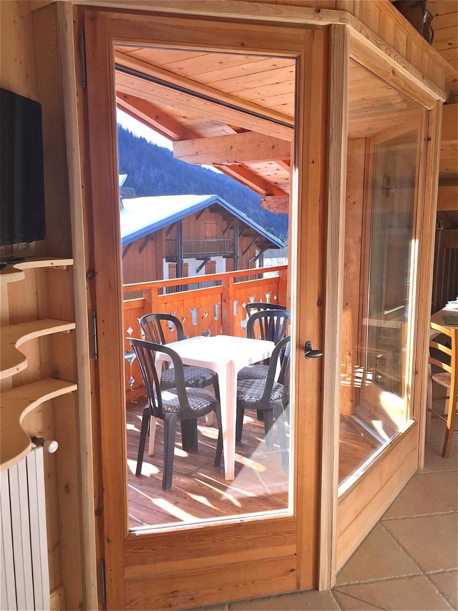 une véranda avec une table et des chaises dans l'établissement Apart'hotel & Spa "La Destière", à La Giettaz