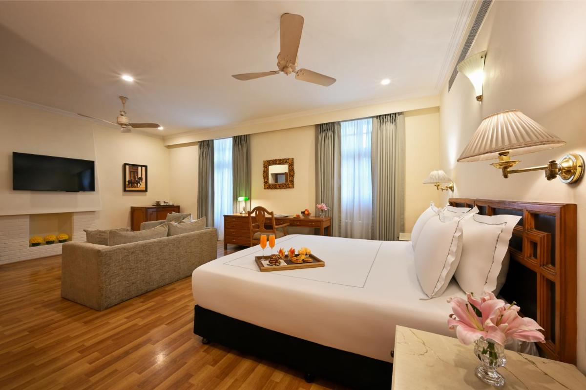 a bedroom with a large bed and a living room at Ambassador, New Delhi - IHCL SeleQtions in New Delhi a bedroom with a large bed and a living room at Ambassador, New Delhi - IHCL SeleQtions in New Delhi