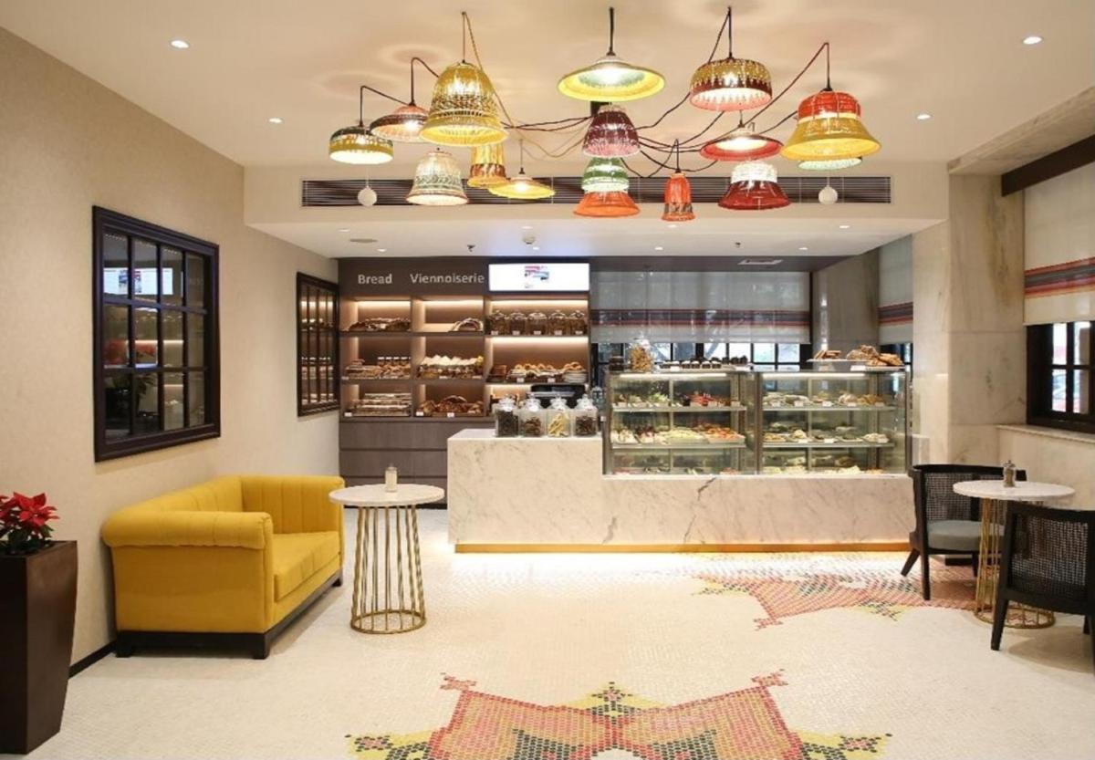 a bakery with a yellow chair and a counter at Ambassador, New Delhi - IHCL SeleQtions in New Delhi a bakery with a yellow chair and a counter at Ambassador, New Delhi - IHCL SeleQtions in New Delhi