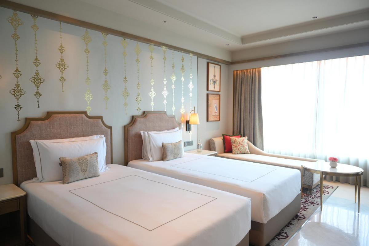 a hotel room with two beds and a window at Taj Agra in Agra