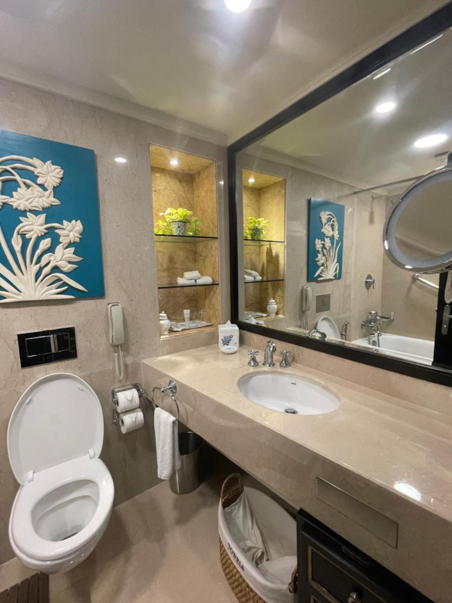 a bathroom with a toilet and a sink and a mirror at ITC Maurya, a Luxury Collection Hotel, New Delhi in New Delhi a bathroom with a toilet and a sink and a mirror at ITC Maurya, a Luxury Collection Hotel, New Delhi in New Delhi