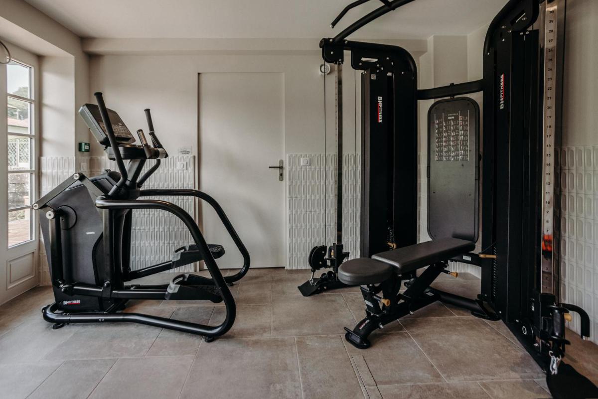 une salle avec une salle de sport avec un tapis roulant dans l'établissement Hotel Trinquet, à Saint-Pée-sur-Nivelle