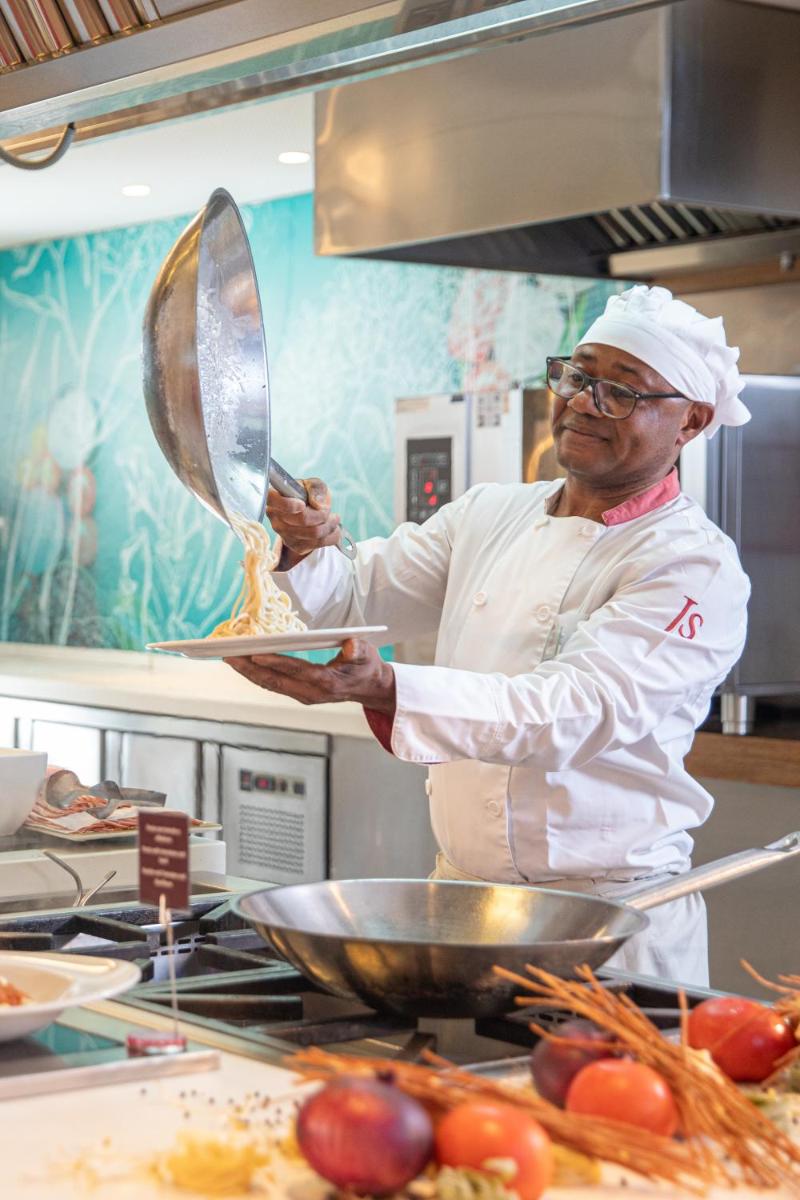 un chef de pie en una cocina preparando comida en JS Palma Stay - Adults Only, en Can Pastilla