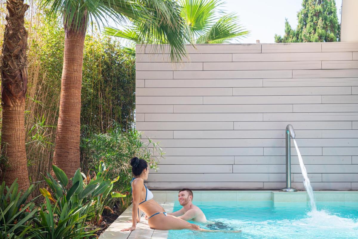 un hombre y una mujer sentados en una piscina en JS Palma Stay - Adults Only, en Can Pastilla