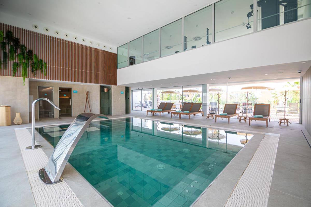 una piscina con un tobogán en un edificio en JS Sol de Alcudia, en Puerto de Alcudia