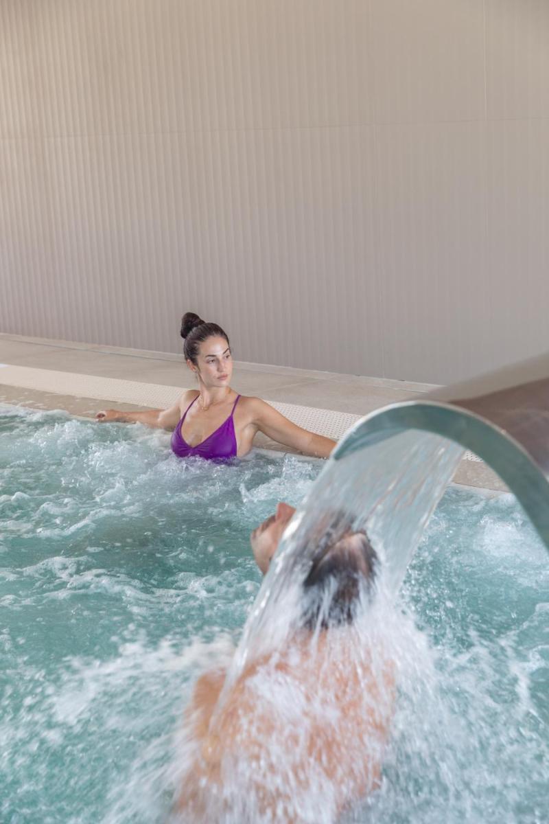 una mujer en una piscina con un hombre en JS Sol de Alcudia, en Puerto de Alcudia