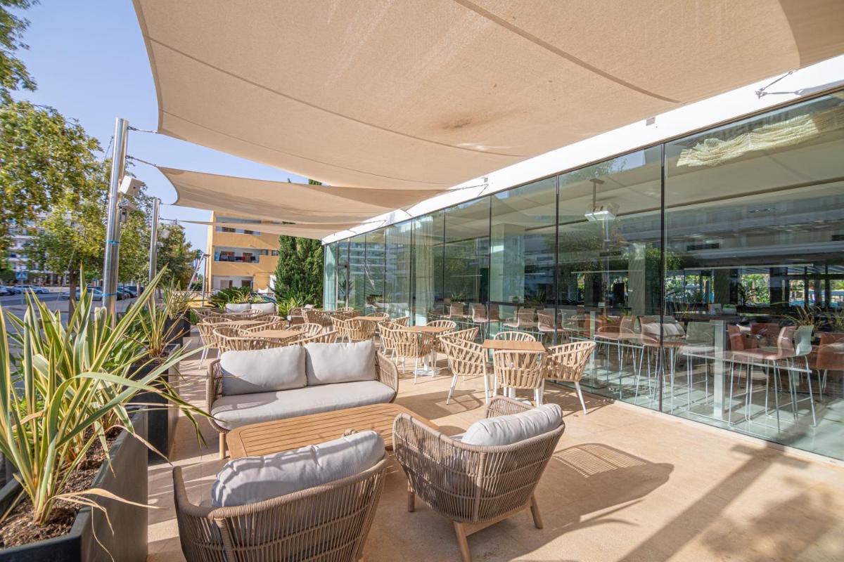 Un patio al aire libre con mesas y sillas y un edificio. en JS Sol de Alcudia, en Puerto de Alcudia