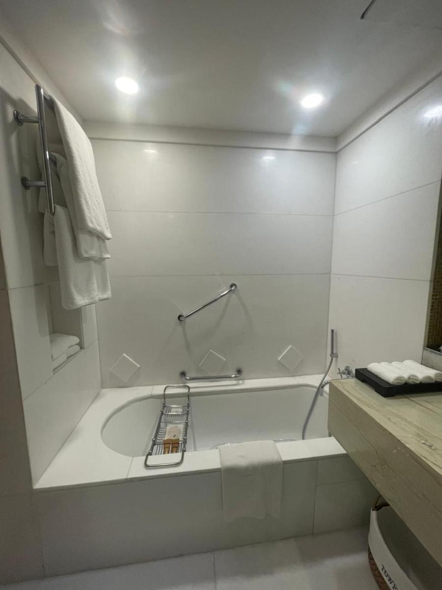 a white bathroom with a tub and a towel at ITC Maurya, a Luxury Collection Hotel, New Delhi in New Delhi a white bathroom with a tub and a towel at ITC Maurya, a Luxury Collection Hotel, New Delhi in New Delhi