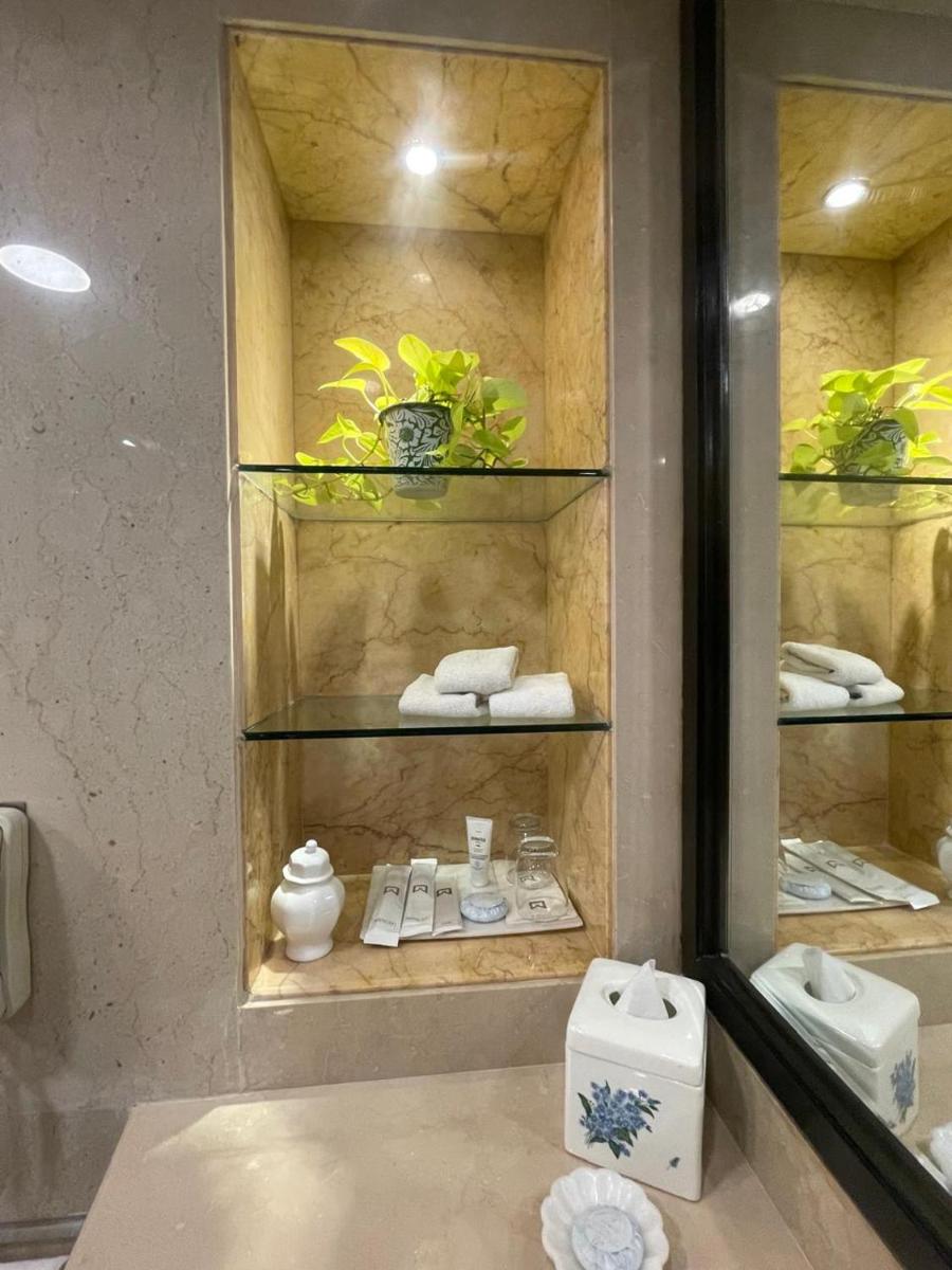 a bathroom with a mirror and shelves with towels at ITC Maurya, a Luxury Collection Hotel, New Delhi in New Delhi a bathroom with a mirror and shelves with towels at ITC Maurya, a Luxury Collection Hotel, New Delhi in New Delhi