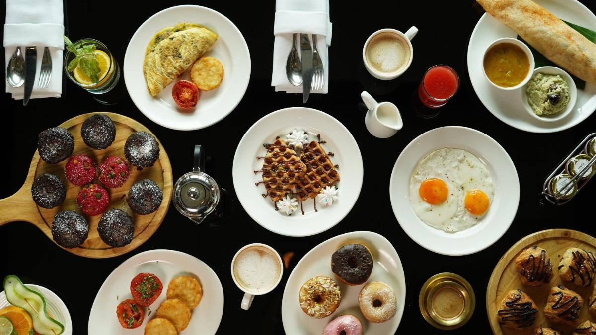 a table with plates of breakfast foods on it at InterContinental Marine Drive Mumbai by IHG in Mumbai