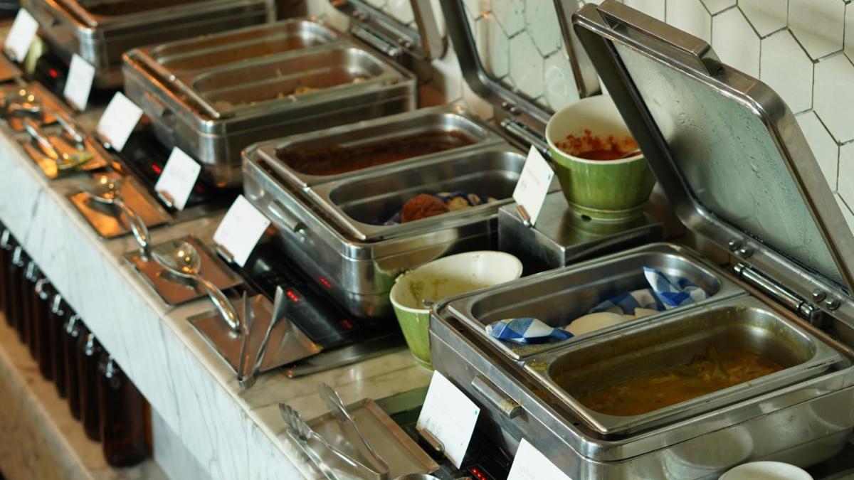 a kitchen with several sinks and trays of food at InterContinental Marine Drive Mumbai by IHG in Mumbai