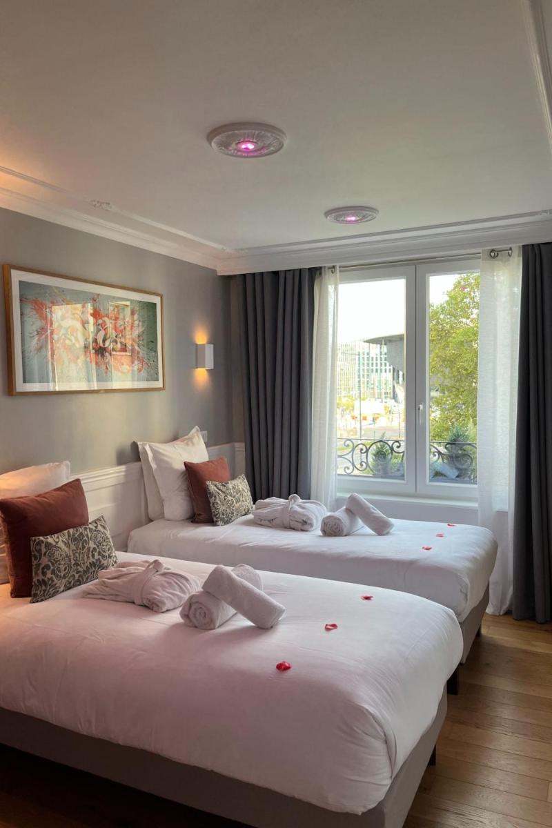 deux lits dans une chambre d'hôtel avec une fenêtre dans l'établissement Au 30 Lille Centre Grand Palais, à Lille