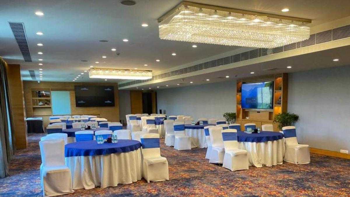 a banquet hall with blue tables and white chairs at Crowne Plaza Today Gurugram by IHG in Gurgaon