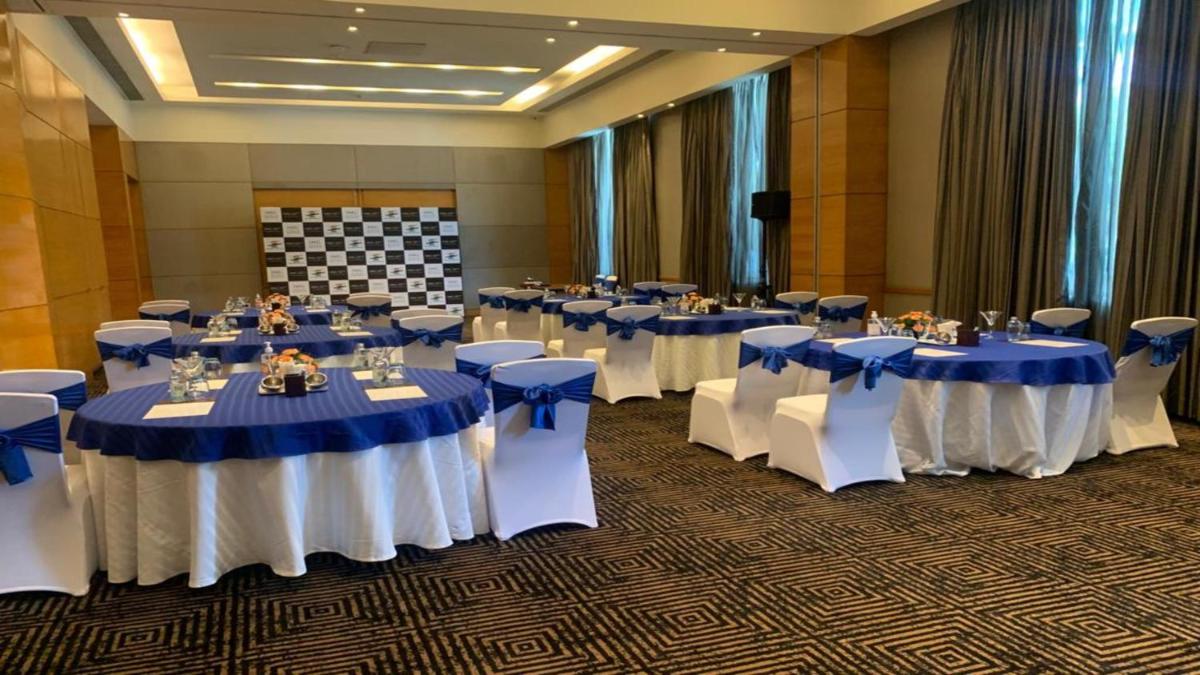 a room filled with tables with blue and white tablecloths at Crowne Plaza Today Gurugram by IHG in Gurgaon