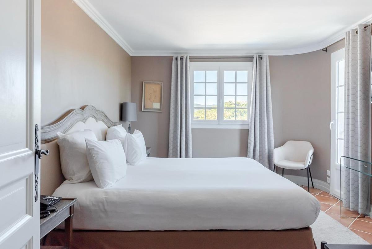 une chambre avec un grand lit blanc et une fenêtre dans l'établissement Maison Bérard Hôtel - Restaurant - Spa, à La Cadière-dʼAzur