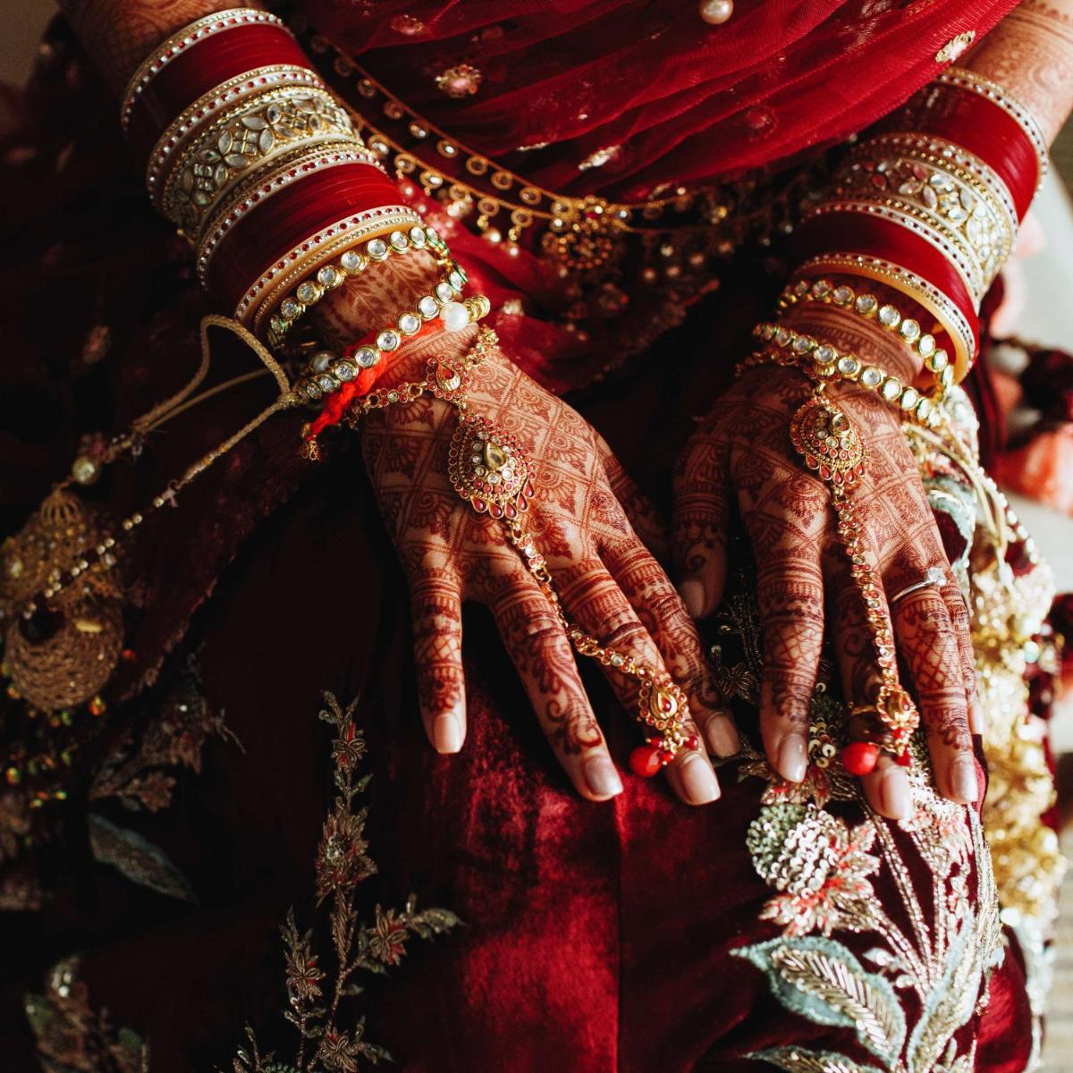 a bride and groom with their hands on their wedding dress at Radisson Blu Hotel Amritsar in Amritsar