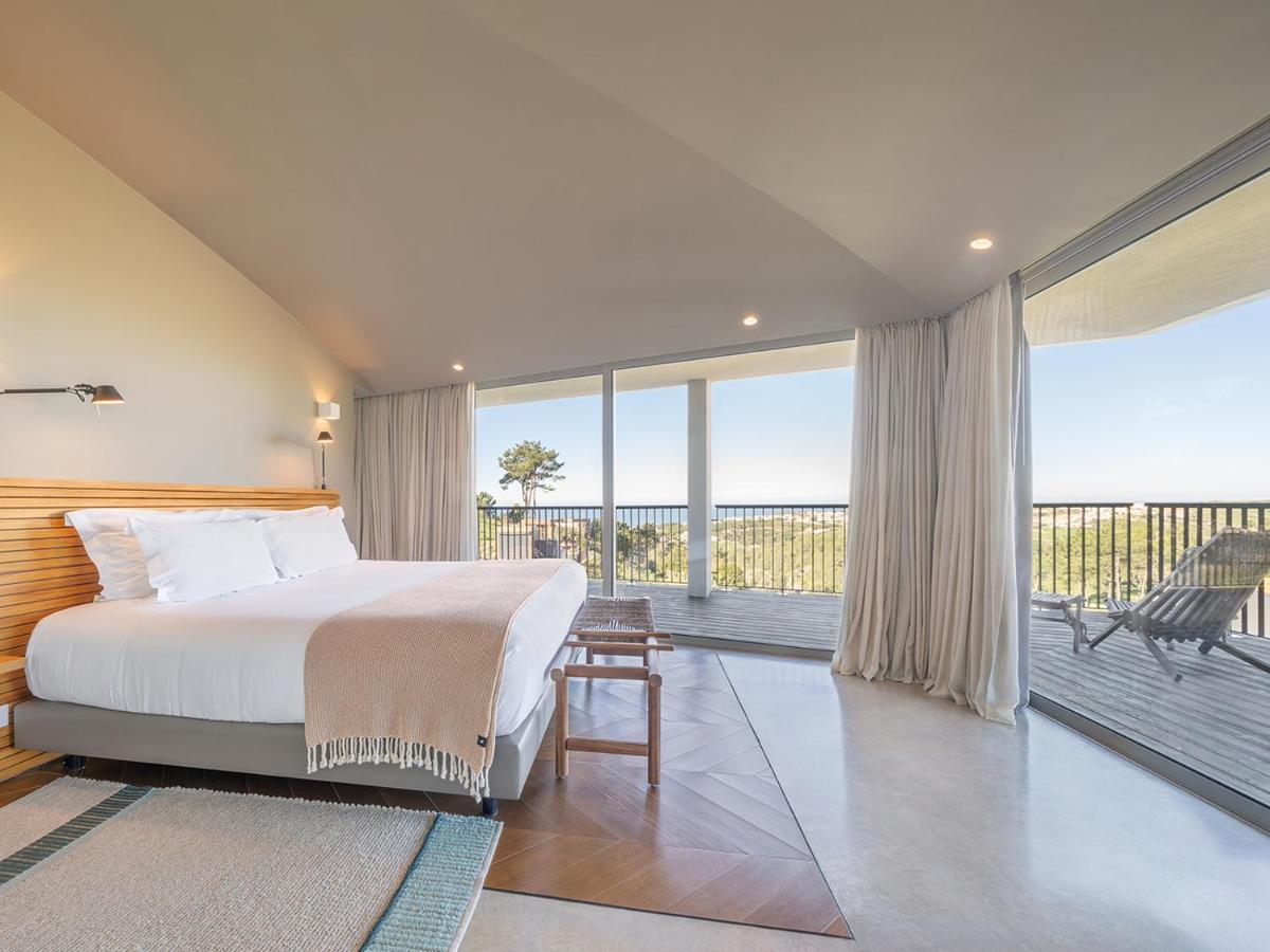 um quarto com uma cama e uma varanda em Immerso Hotel, a Member of Design Hotels na Ericeira mais 120 fotografias