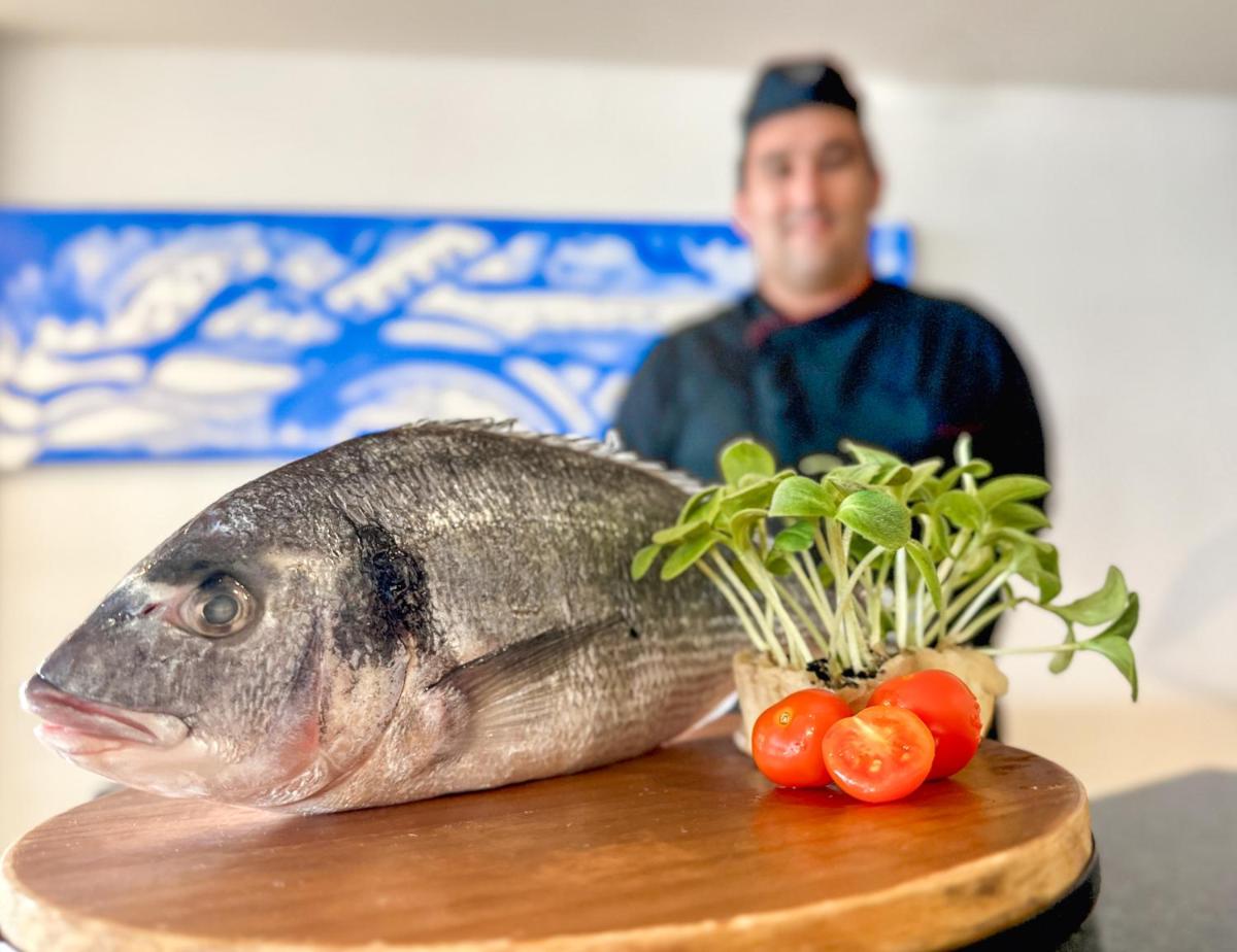 Un pez sentado en una tabla de cortar junto a tomates. en Hotel Na Forana, en Cala Ratjada 102 fotos más