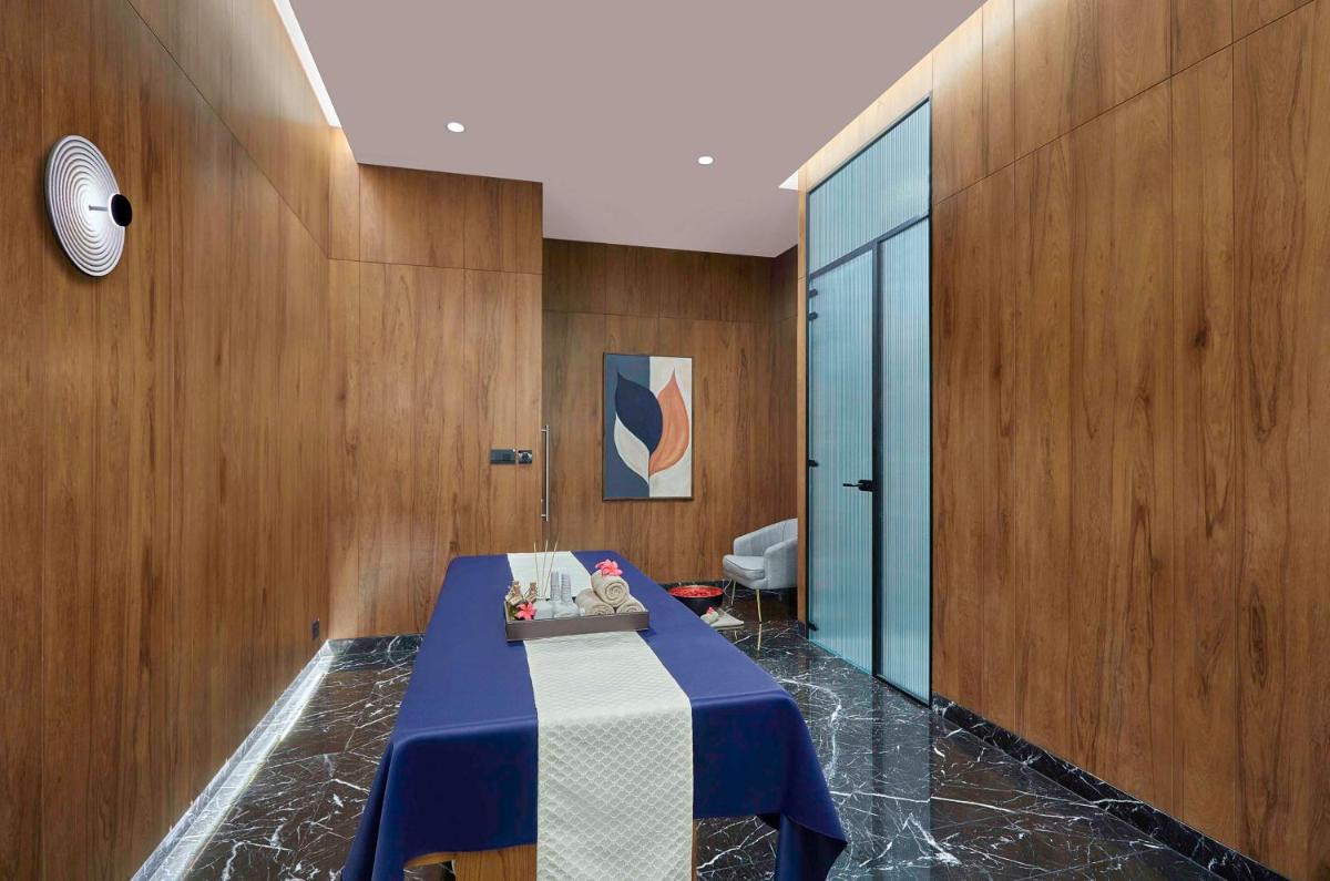 a room with a blue table in a room with wooden walls at Hilton Bengaluru Embassy Manyata Business Park in Bengaluru