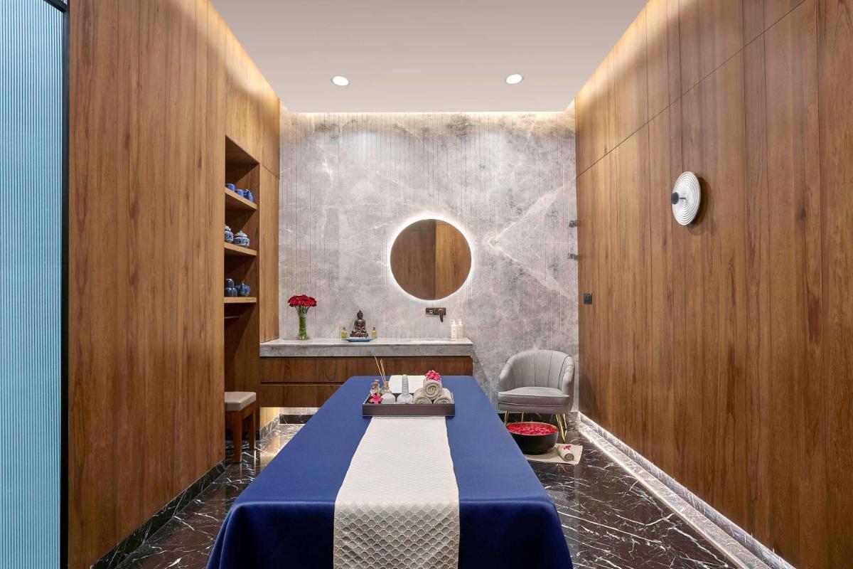 a dining room with a blue table and a mirror at Hilton Bengaluru Embassy Manyata Business Park in Bengaluru