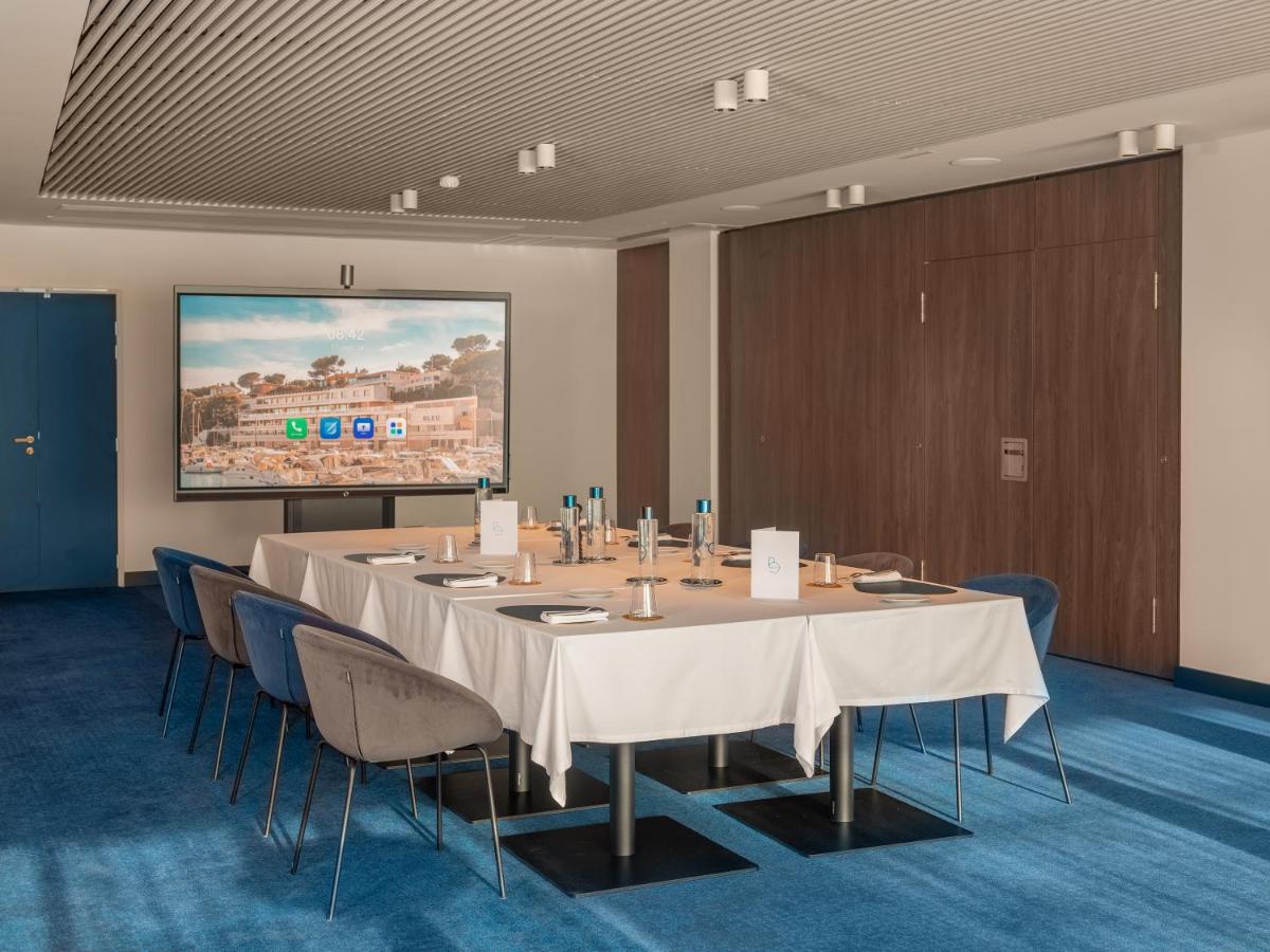une salle de conférence avec une table, des chaises et un écran dans l'établissement Bleu Hôtel & Spa, à Carry-le-Rouet