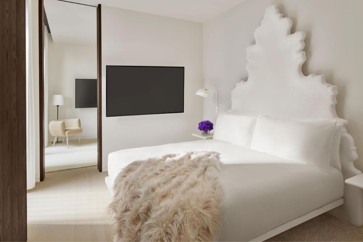 1 dormitorio blanco con 1 cama blanca grande con manta peluda en The Madrid EDITION, en Madrid