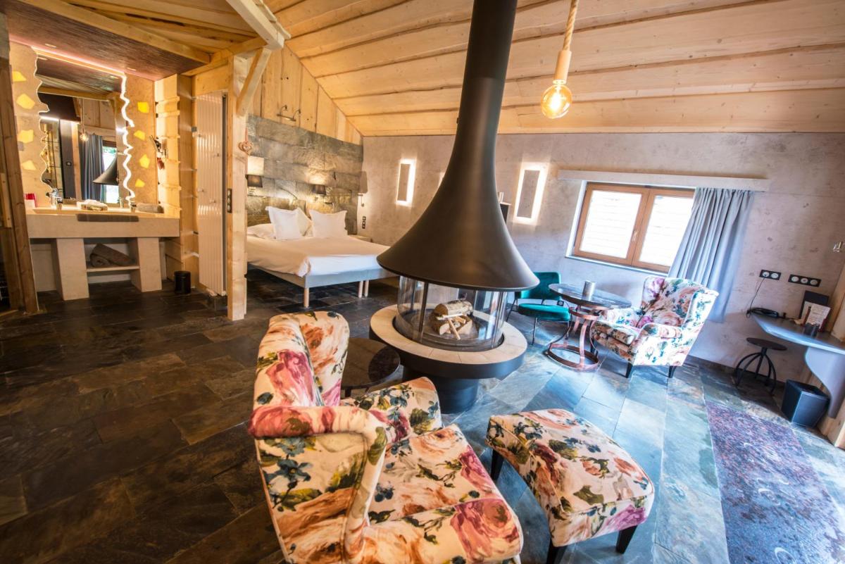 - un salon avec des canapés et une cheminée dans une maison dans l'établissement Domaine du Haut Jardin Hôtel & Chalets Spa Privé, à Rehaupal