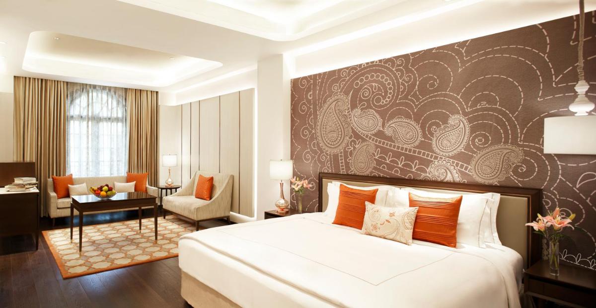 a bedroom with a bed and a living room at Taj Mahal Lucknow in Lucknow