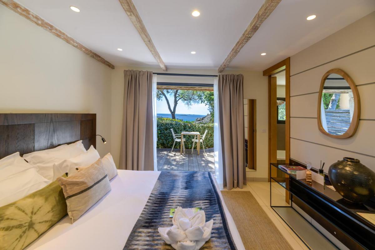 une chambre avec un lit et une vue sur l'océan dans l'établissement Les Bergeries De Palombaggia, à Porto-Vecchio 37 autres photos une chambre avec un lit et une vue sur l'océan dans l'établissement Les Bergeries De Palombaggia, à Porto-Vecchio 37 autres photos