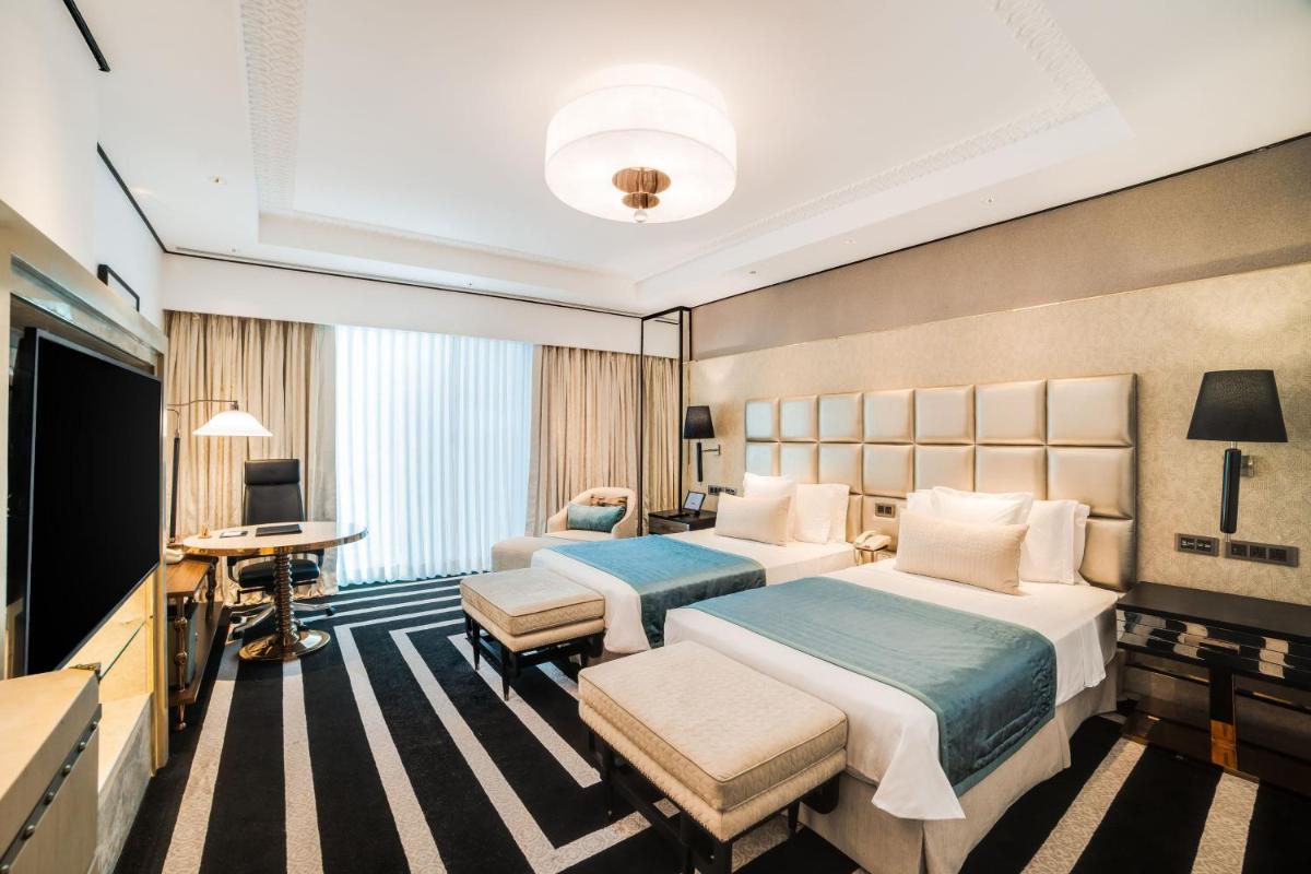 a hotel room with two beds and a flat screen tv at ITC Narmada, a Luxury Collection Hotel, Ahmedabad in Ahmedabad