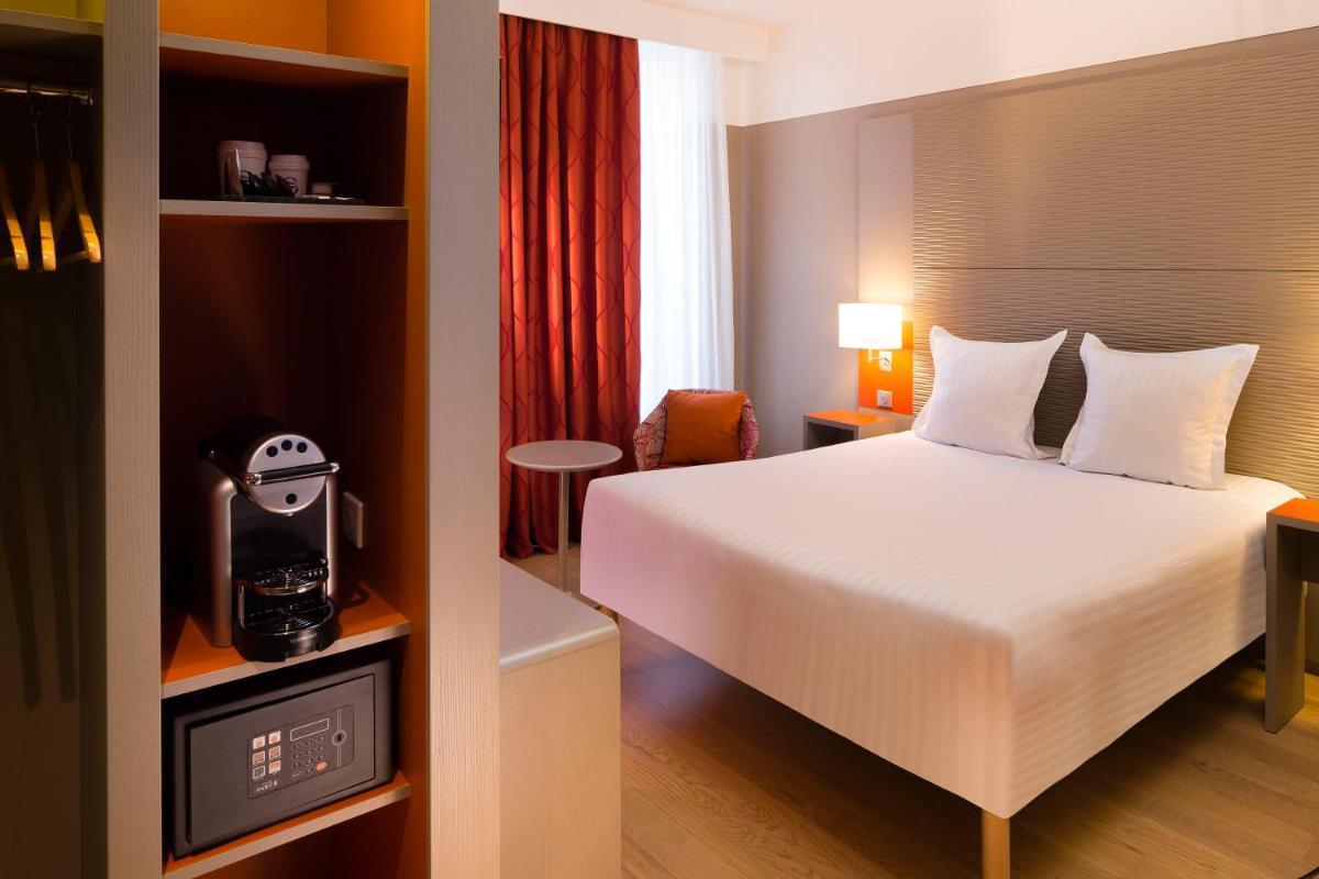 une chambre d'hôtel avec un lit et une télévision dans l'établissement Oceania Le Jura Dijon, à Dijon