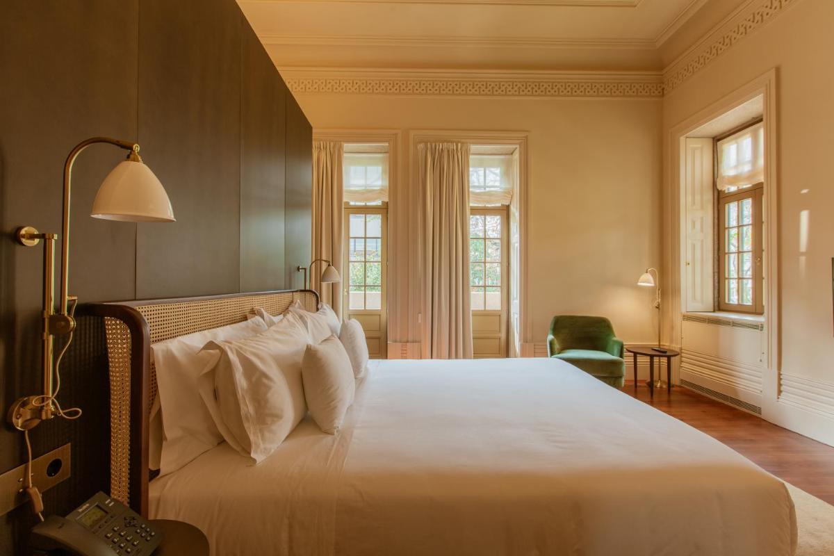 um quarto com uma cama grande com travesseiros brancos em Palacete Severo no Porto mais 51 fotografias