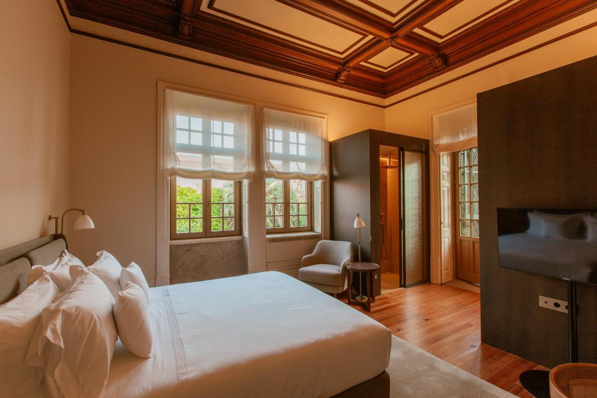 um quarto com uma cama grande e uma TV em Palacete Severo no Porto