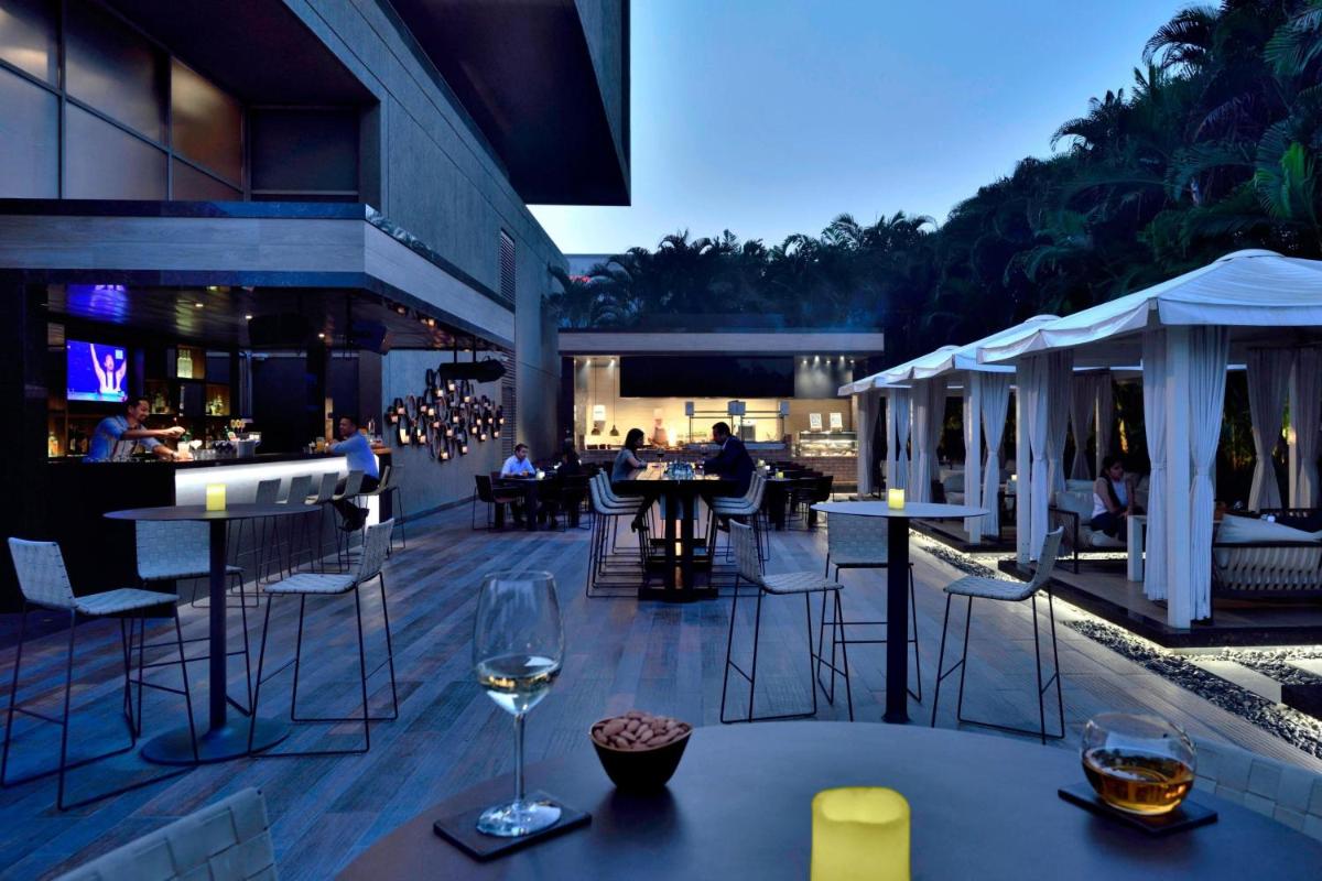 a restaurant with tables and chairs and a bar at Courtyard by Marriott Pune Hinjewadi in Pune