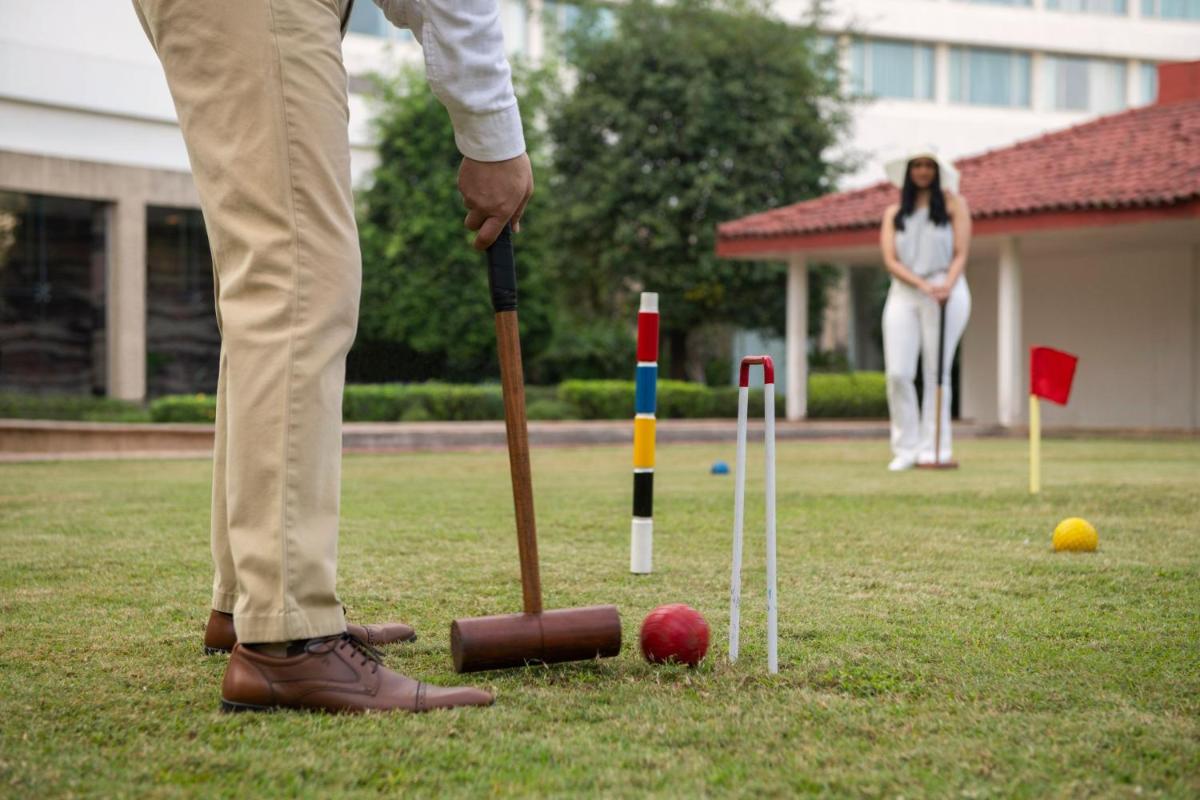 a man is playing a game of cricket at The Westin Mumbai Powai Lake in Mumbai