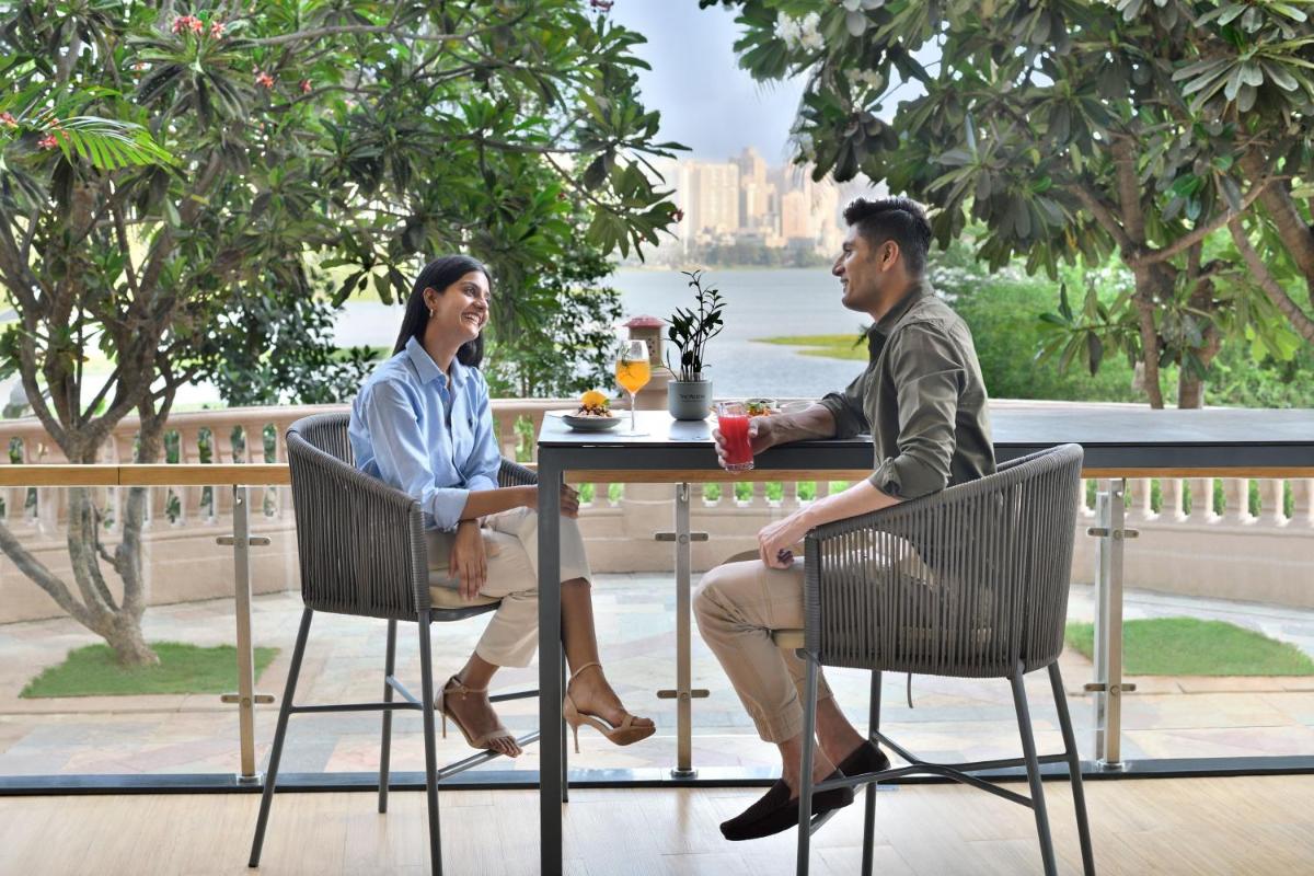 a man and a woman sitting at a table at The Westin Mumbai Powai Lake in Mumbai