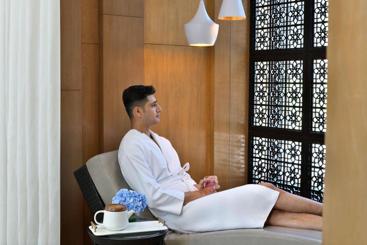 a man sitting in a chair in a room at The Westin Mumbai Powai Lake in Mumbai
