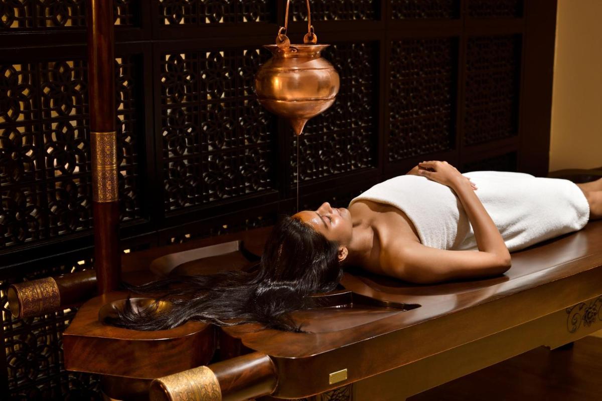 a woman laying in a bath in a bed at The Westin Mumbai Powai Lake in Mumbai