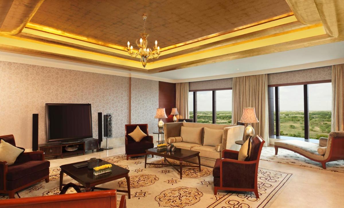 a living room with a couch and a television at The Leela Ambience Gurugram Hotel & Residences - The Luxury Urban Sanctuary in Gurgaon