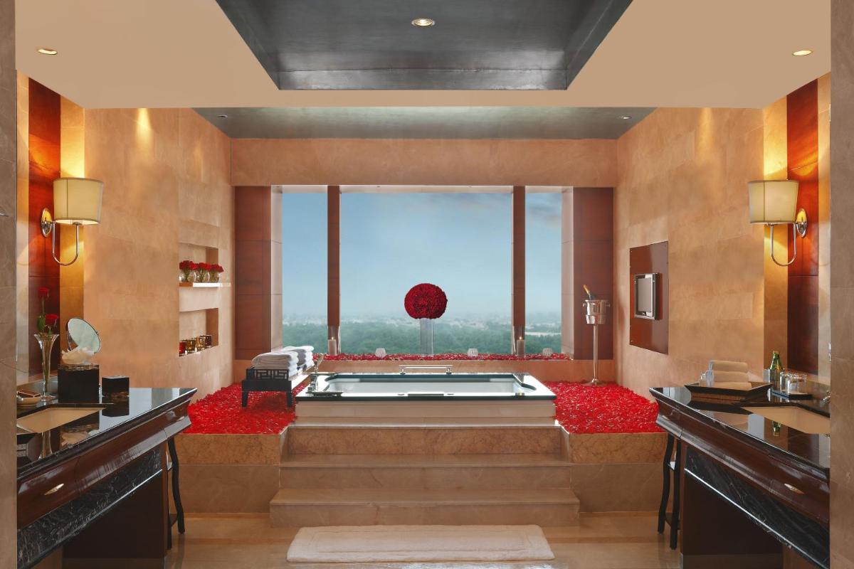 a large bathroom with a tub with a large window at The Leela Ambience Gurugram Hotel & Residences - The Luxury Urban Sanctuary in Gurgaon