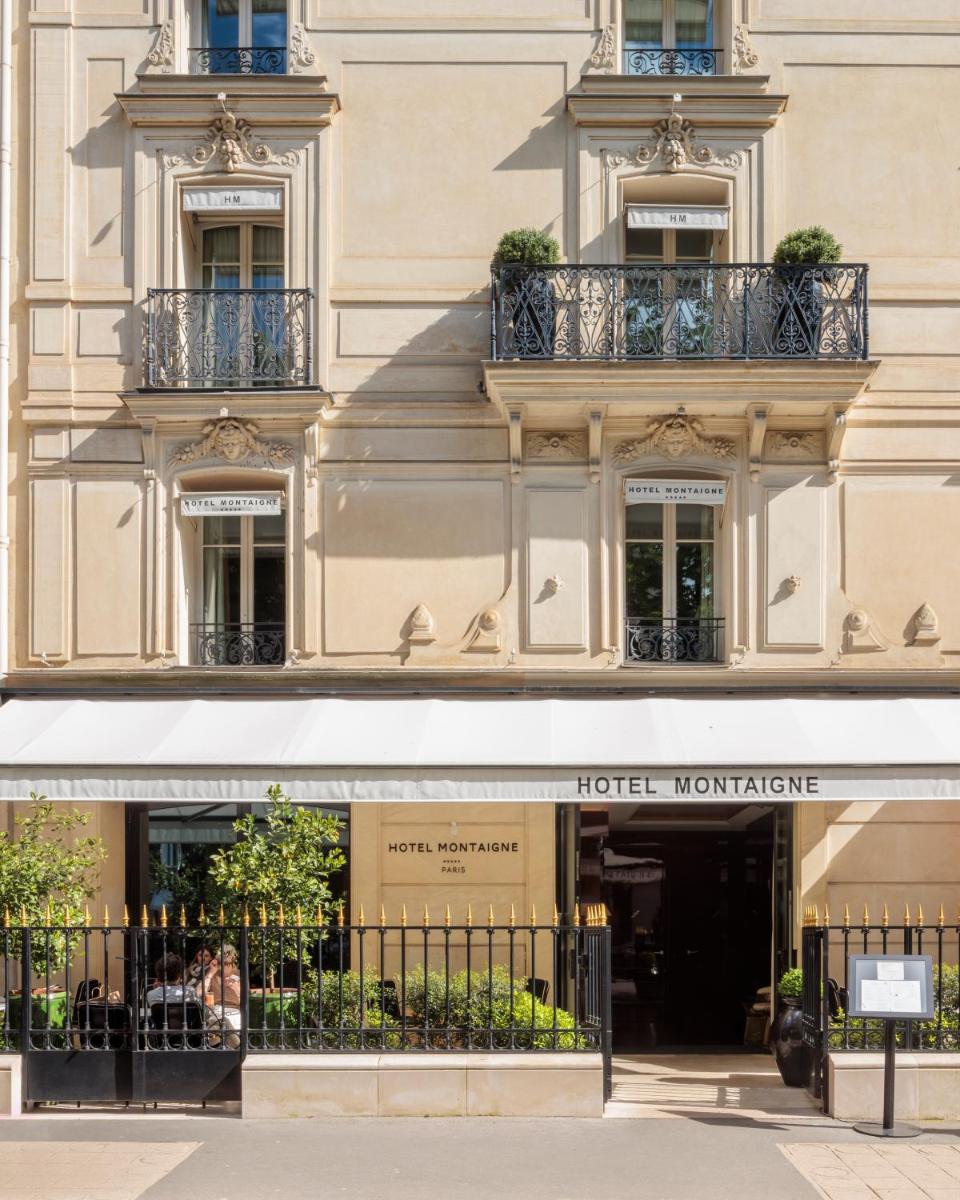 un bâtiment avec un panneau d'affichage mensuel de l'hôtel dans l'établissement Hotel Montaigne, à Paris