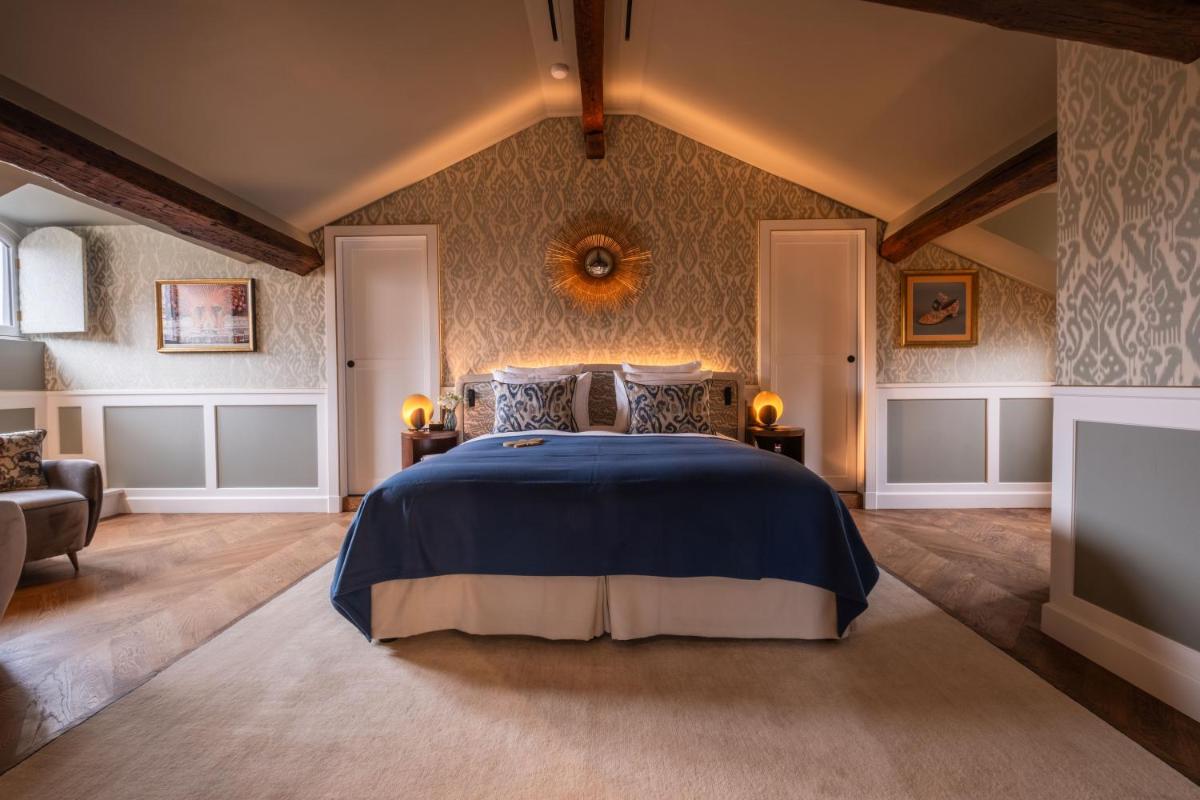 une chambre avec un lit et une télévision dans l'établissement Hôtel Les Lumières - Relais & Châteaux, à Versailles