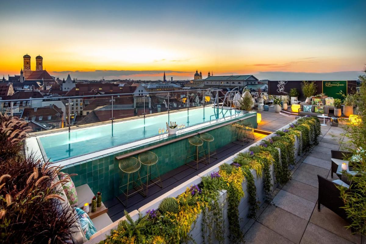 ein Pool auf dem Dach eines Gebäudes mit Sonnenuntergang in der Unterkunft Mandarin Oriental, Munich in München