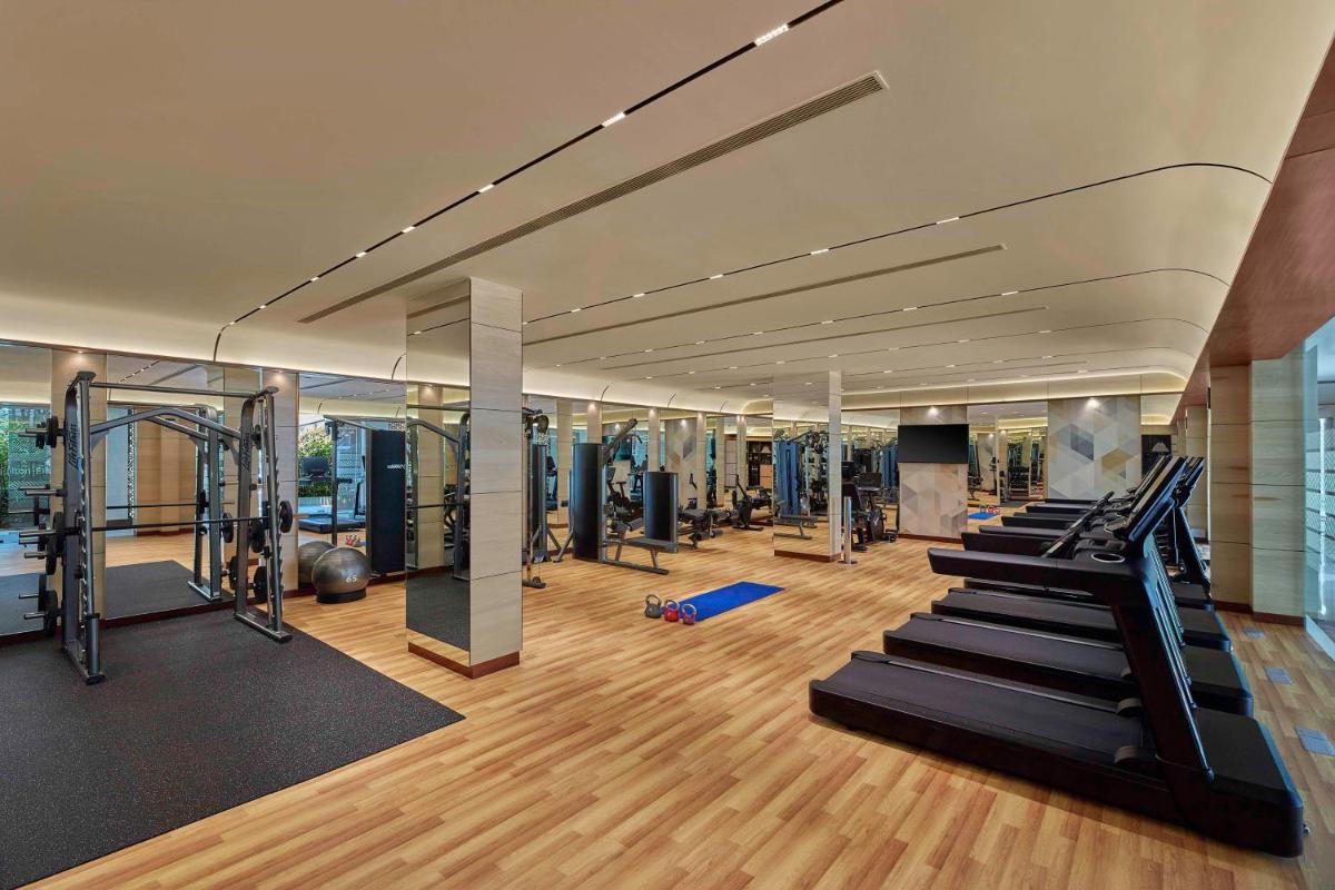 a gym with treadmills and stairs in a building at Hilton Bangalore Embassy GolfLinks in Bengaluru
