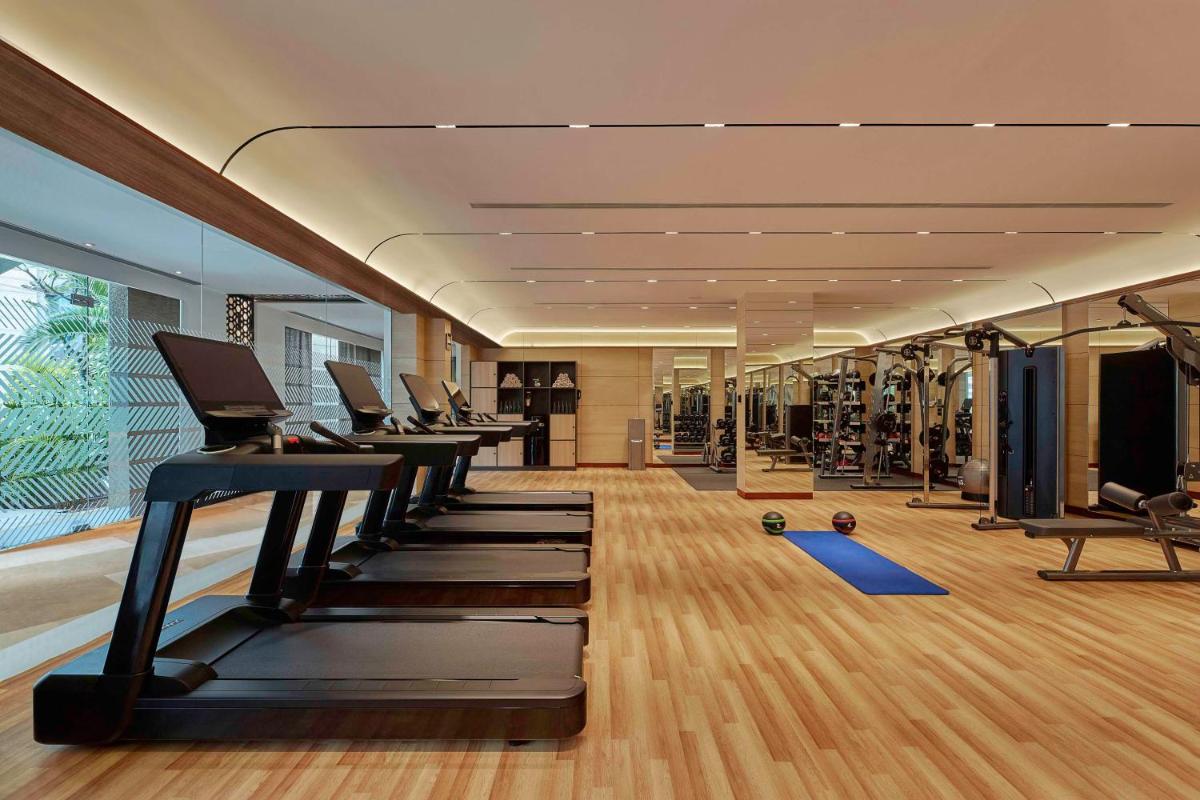 a gym with a row of treadmills at Hilton Bangalore Embassy GolfLinks in Bengaluru