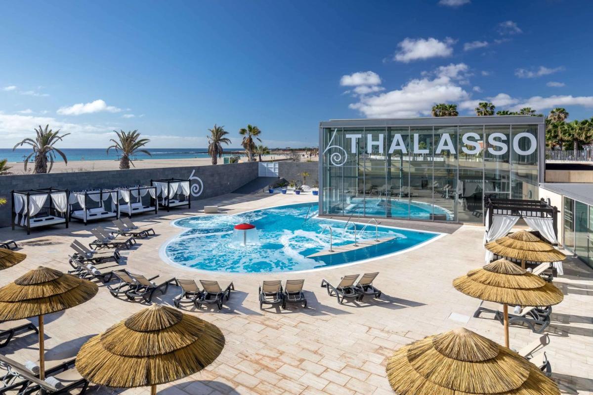 un complejo con piscina, sillas y sombrillas en Barceló Fuerteventura Castillo, en Caleta de Fuste